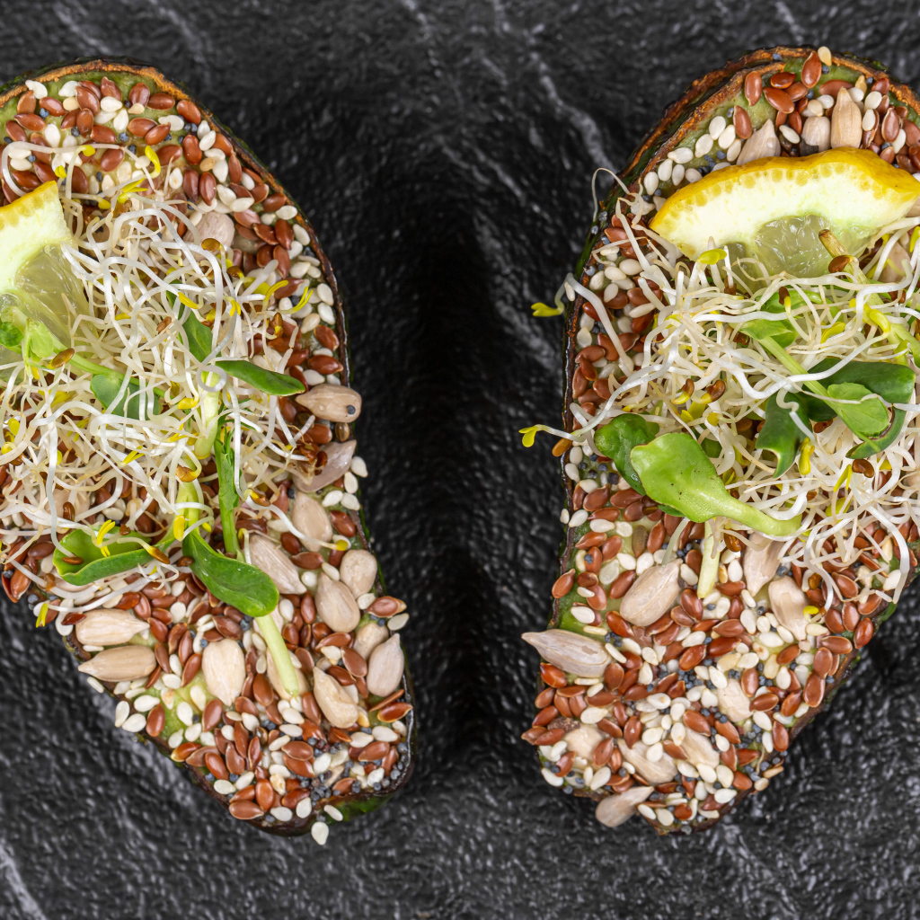 Половинки авокадо с проросшими зернами на столе