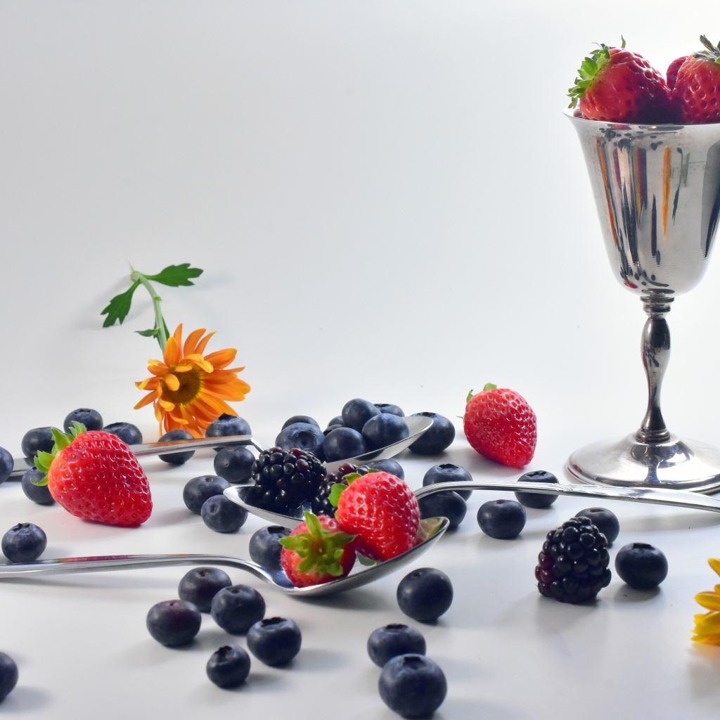 Ежевика, черника и клубника на столе с ложками