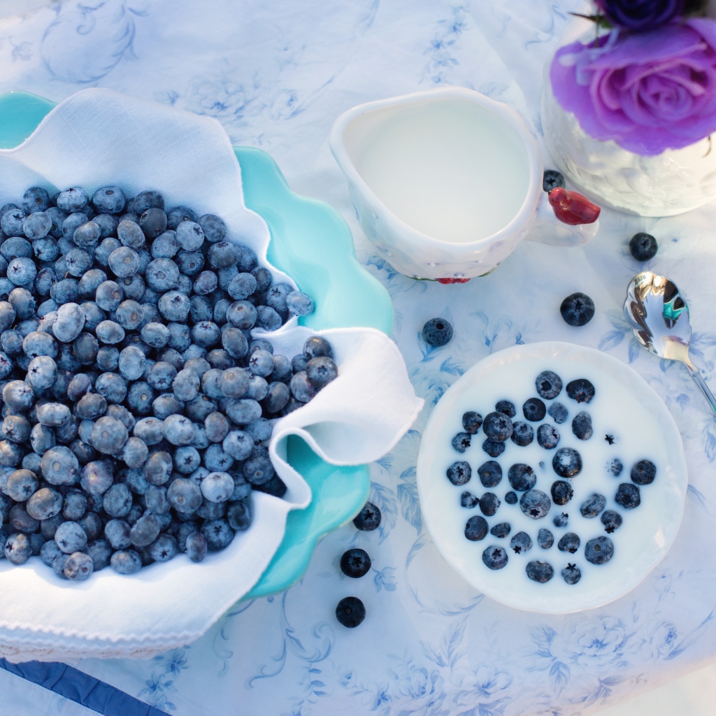 Синие ягоды черники на столе с молоком 