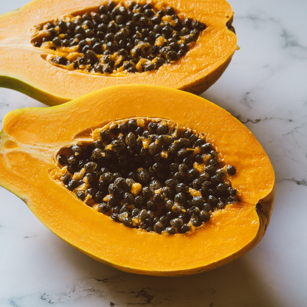 Разрезанный плод папайи на столе 