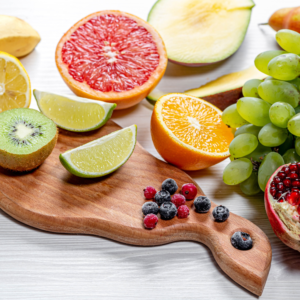 Вкусные цитрусовые фрукты и виноград на столе