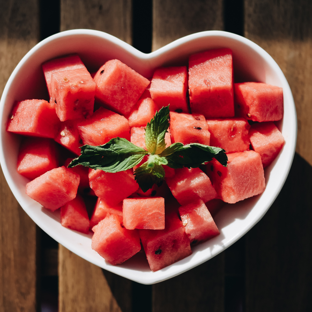 Нарезанный кубиками арбуз в белой тарелке в форме сердца
