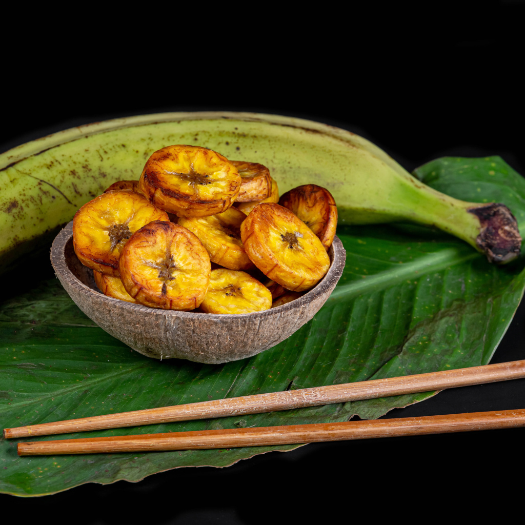 Сушеные бананы на столе с палочками и зеленым листом