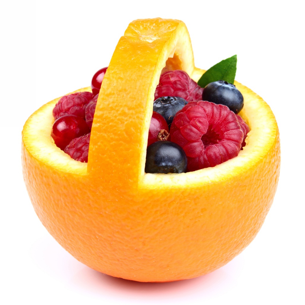 Свежие ягоды в кожуре апельсина на белом фоне