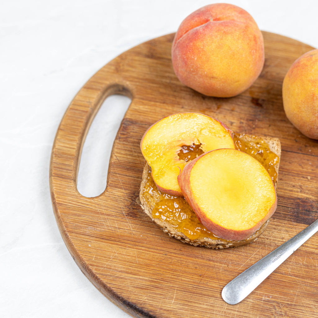 Свежие персики на столе с хлебом 