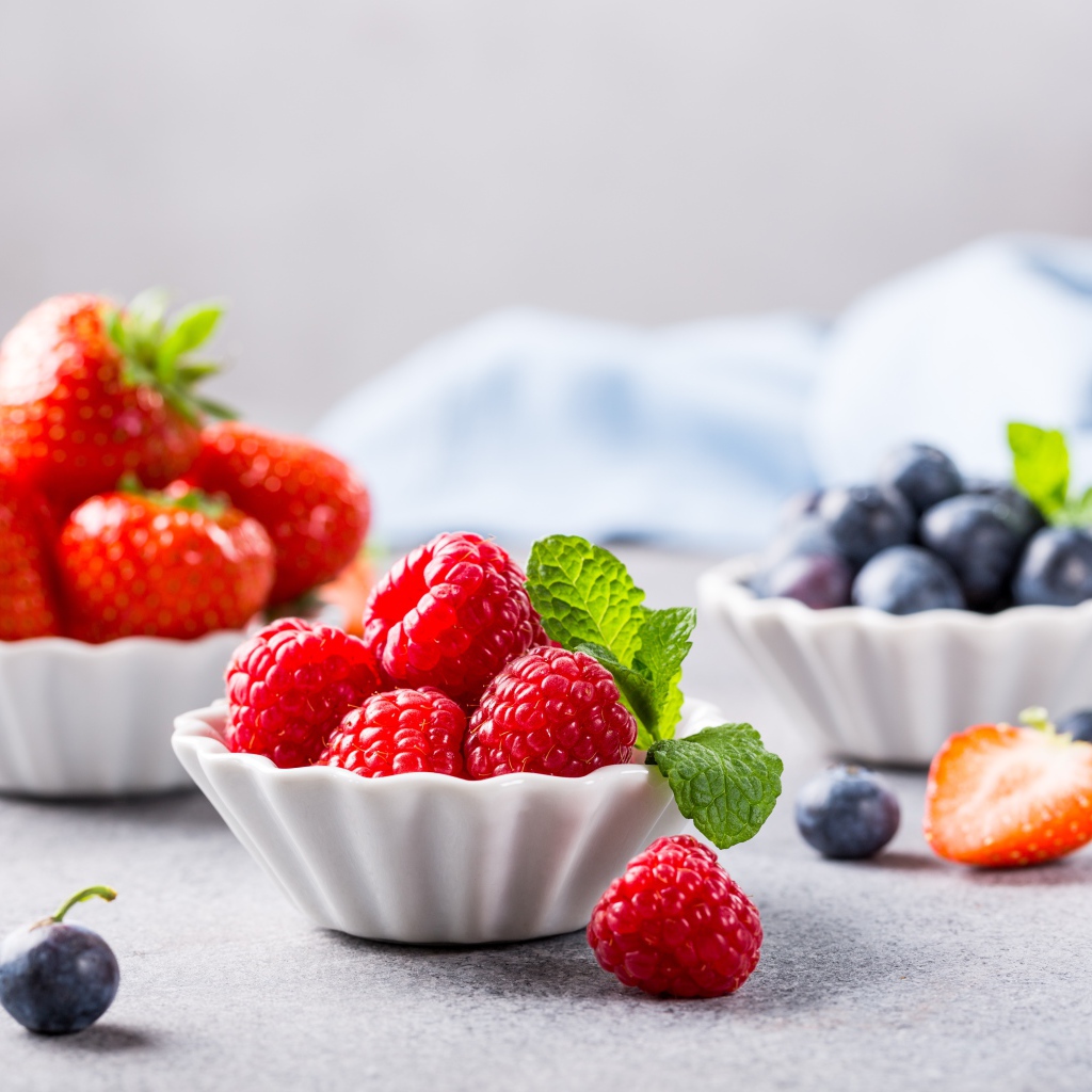 Свежие ягоды малины, клубники и черники на столе