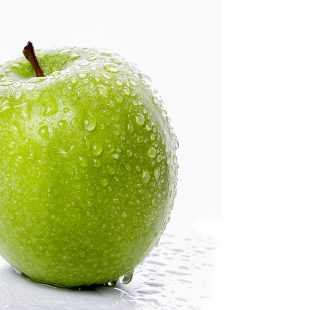 Зеленое яблоко в воде на белом фоне