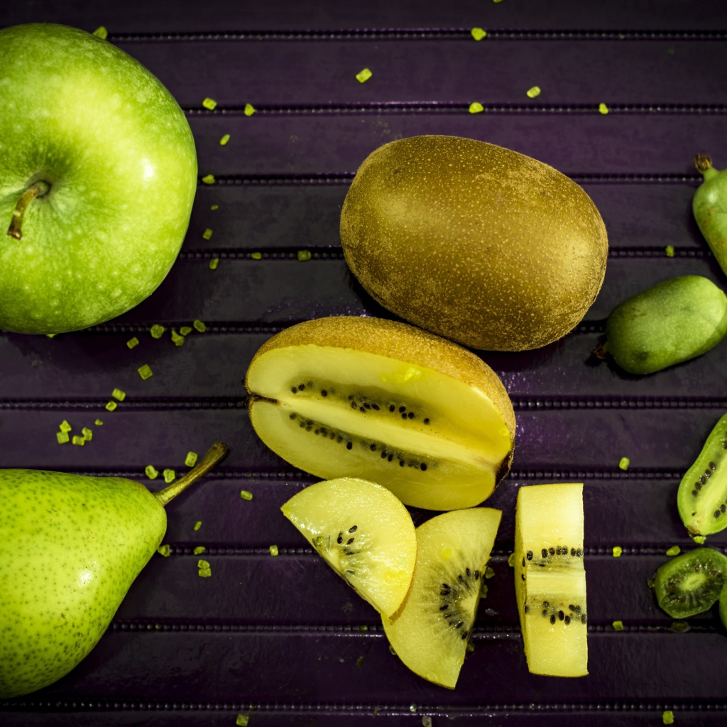 Green apple on the table with pear, kiwi and feijoa