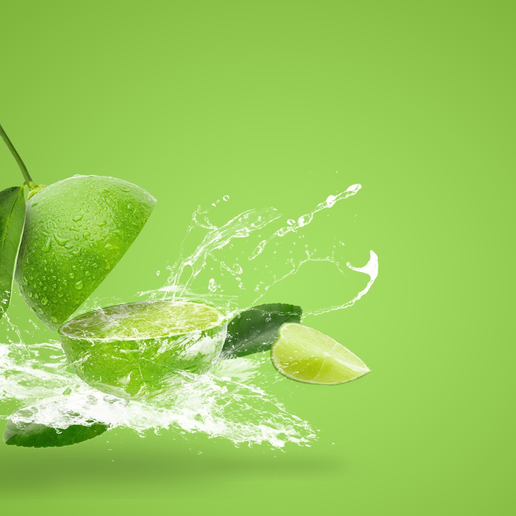 Лайм в брызгах воды на зеленом фоне
