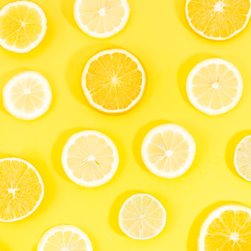 Кружочки апельсина и лимона на желтом фоне