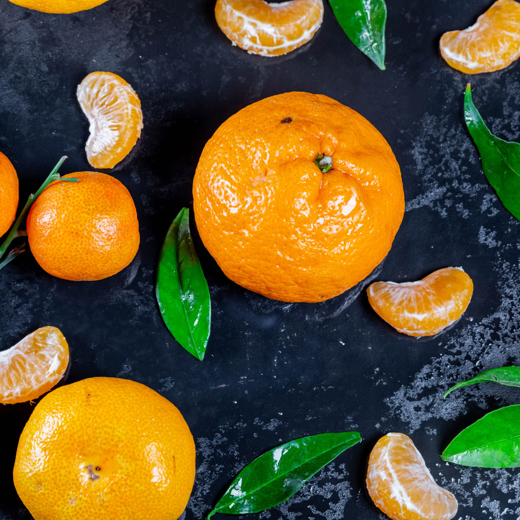 Оранжевые мандарины на мокрой поверхности 