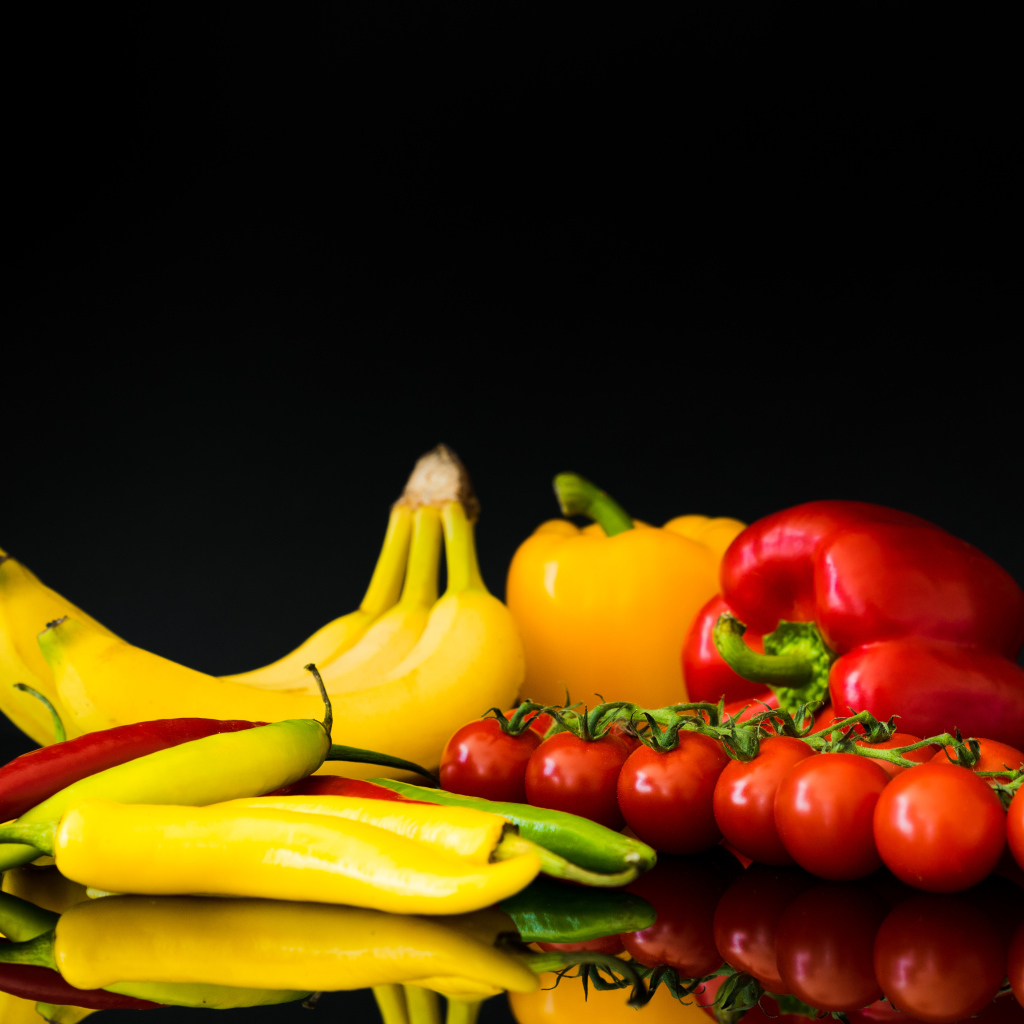 Перец, помидоры и бананы на черном фоне