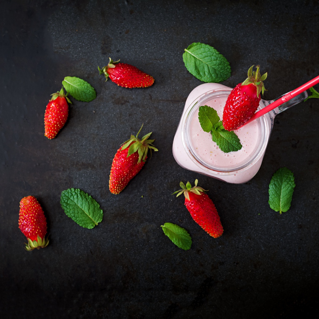 Красная клубника на черном столе с йогуртом