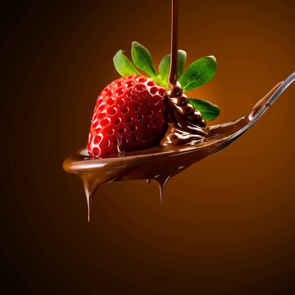 Красная клубника на ложке с молочным шоколадом