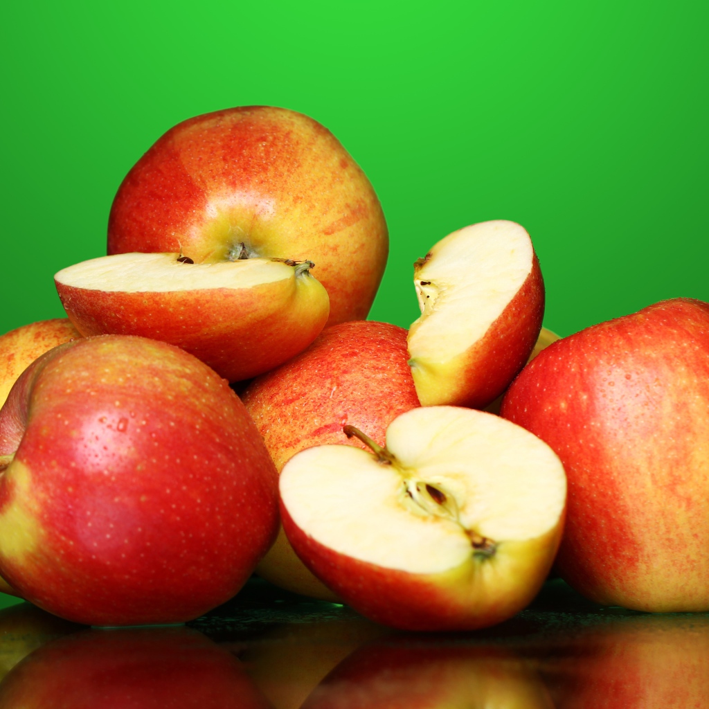 Спелые вкусные красные яблоки на зеленом фоне