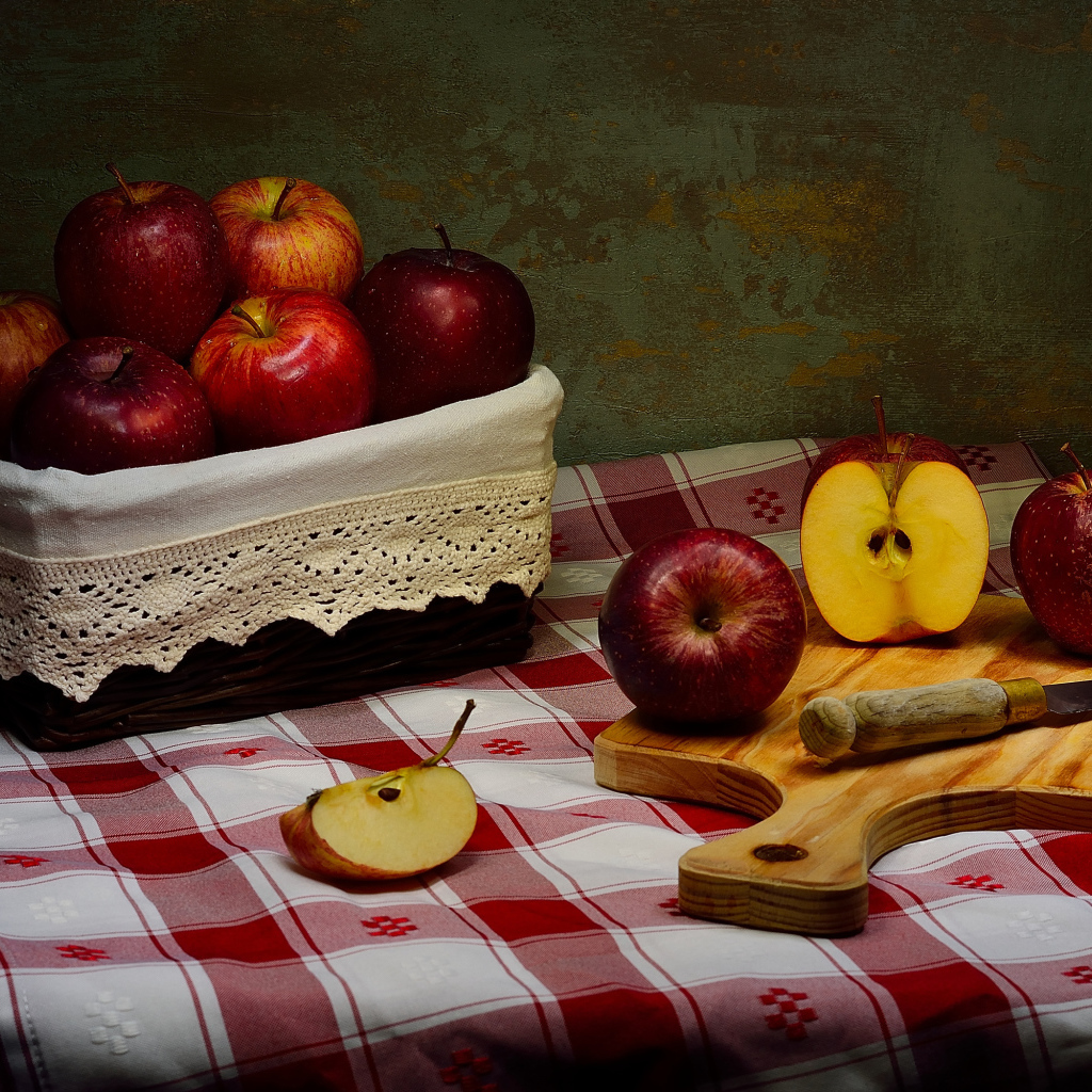 Спелые красные яблоки на столе с ножом