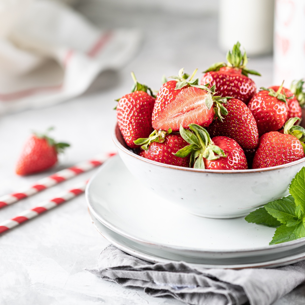 Спелая клубника в тарелке с листьями мяты