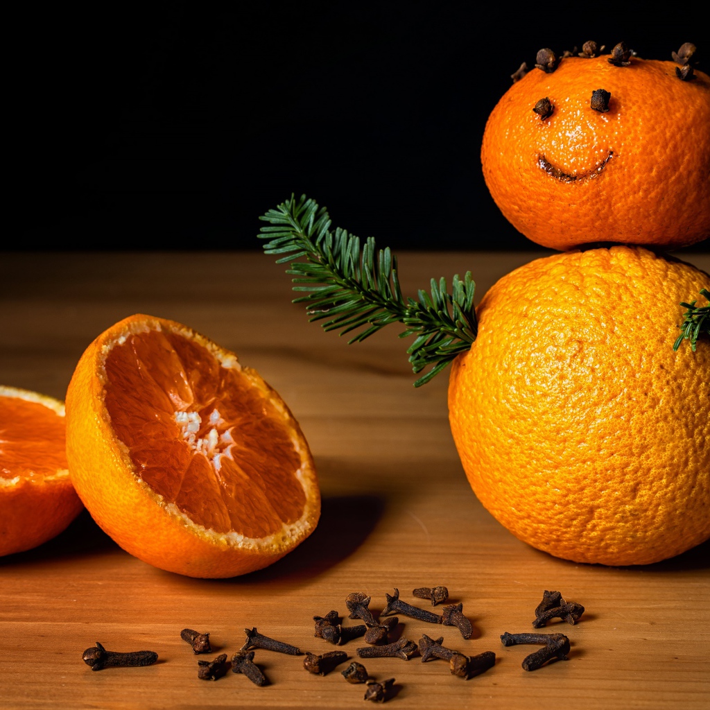 Снеговик из мандаринов и корицы на столе 