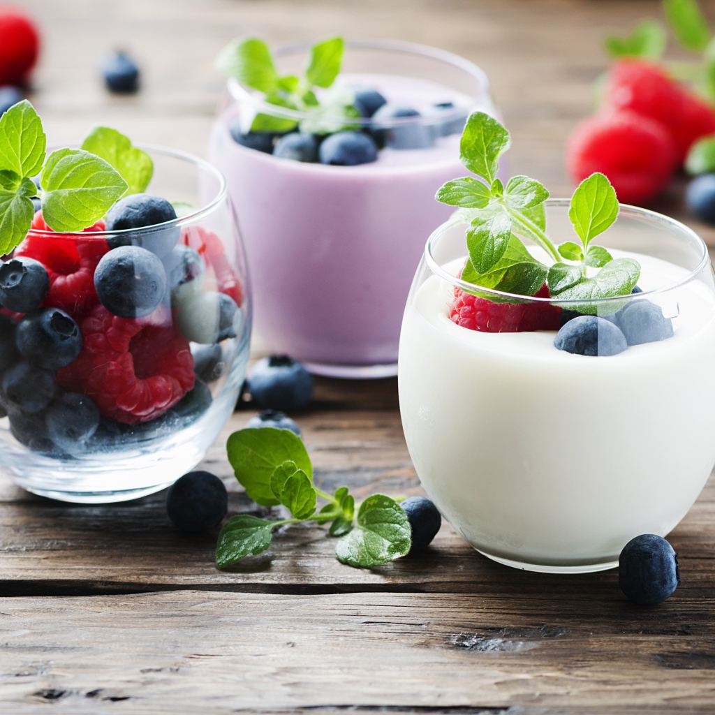 Вкусный йогурт с ягодами черники и малины на столе 