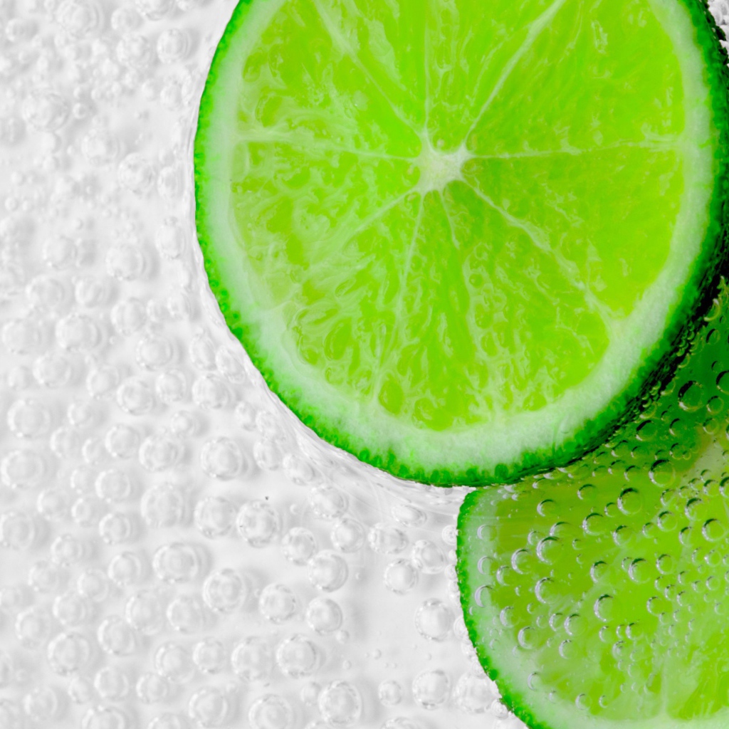 Два куска лайма в пузырях в воде 