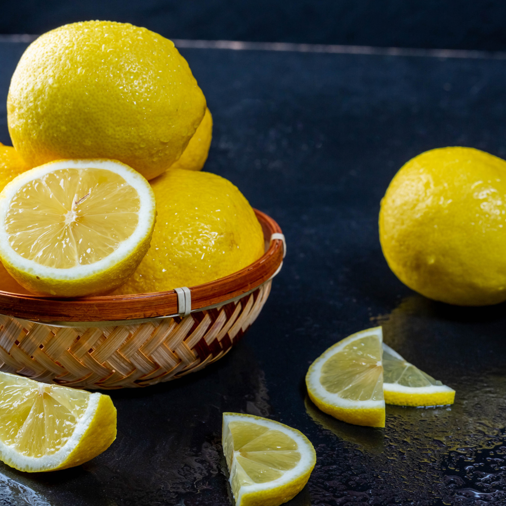 Мокрый лимон с кусочками на черном столе 