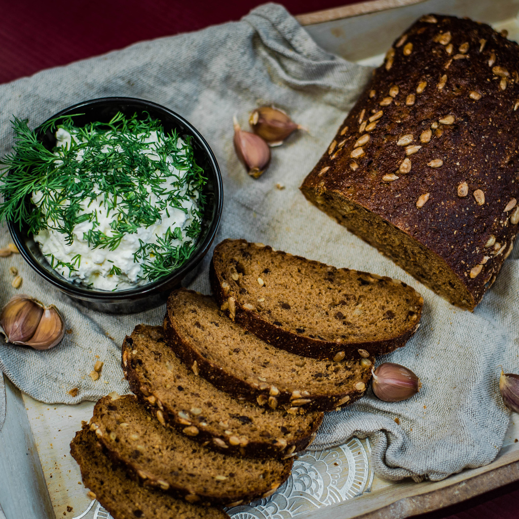 Свежий хлеб с зернами на столе с соусом и чесноком