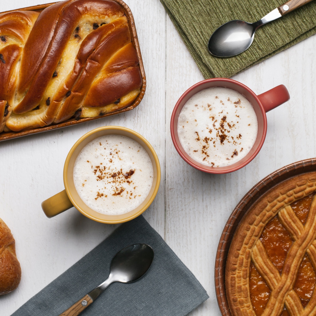 Свежая выпечка и две кружки молока на столе