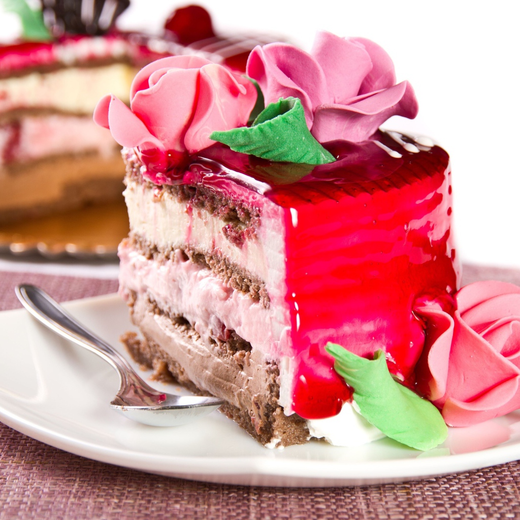 Кусок аппетитного торта декорирован розами из крема