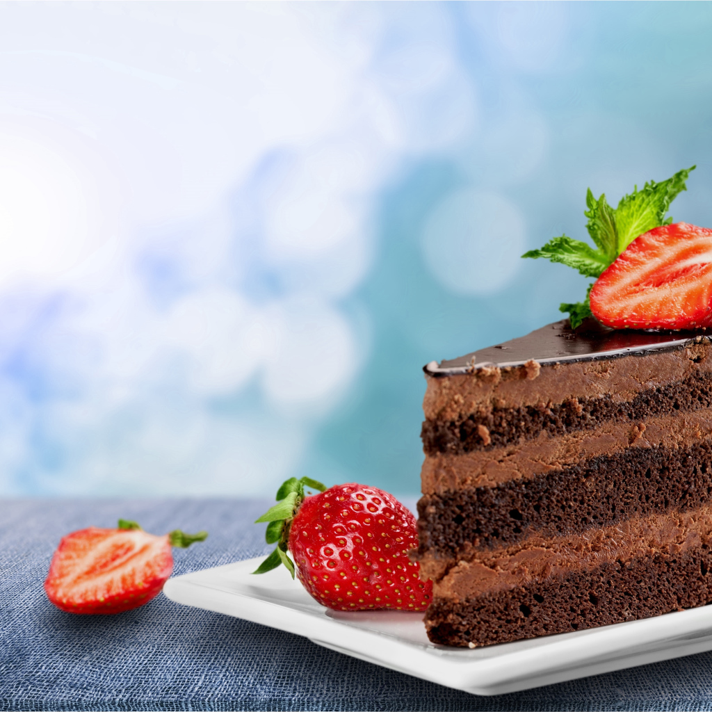 Кусок аппетитного торта с шоколадным кремом и клубникой 