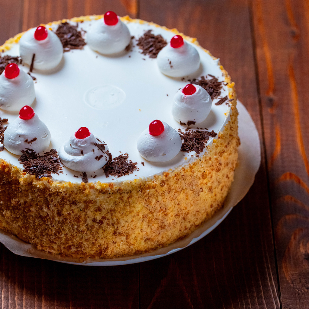 Аппетитный торт с безе на деревянном столе 