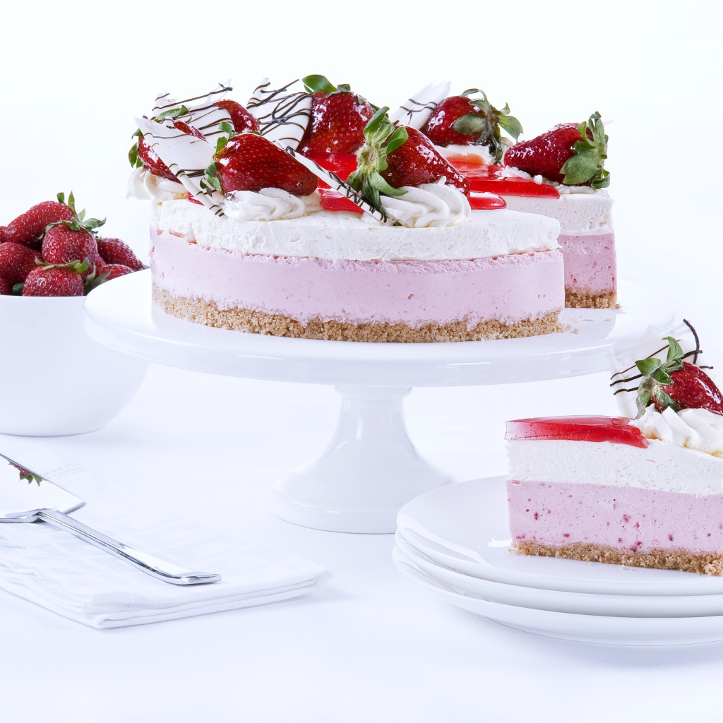 Аппетитный праздничный торт с клубникой на столе 