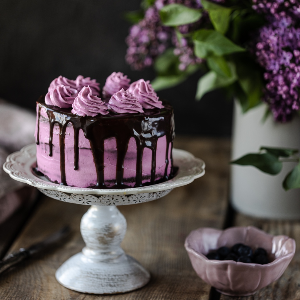 Ягодный торт с шоколадом на столе с сиренью 