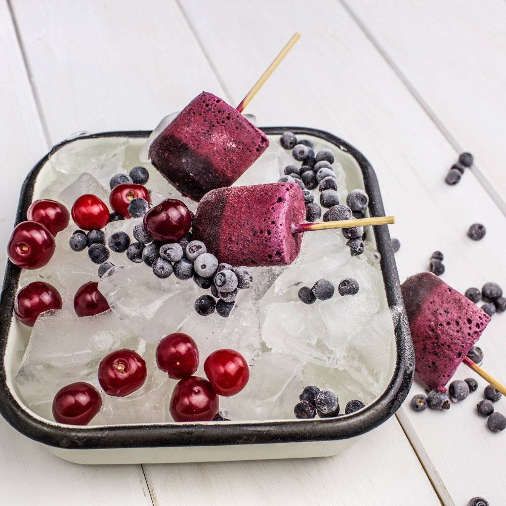 Ягодное мороженое в лотке со льдом, черникой и вишней 