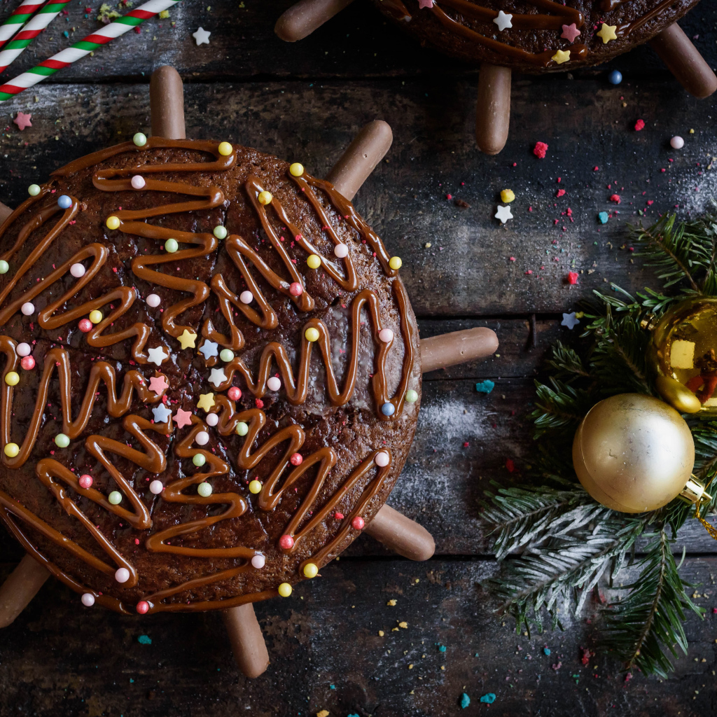 Шоколадное пирожное на столе с еловыми игрушками 