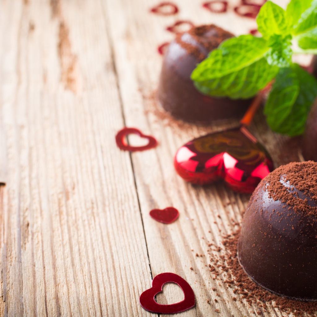 Шоколадные конфеты с какао на столе с мятой и сердечками