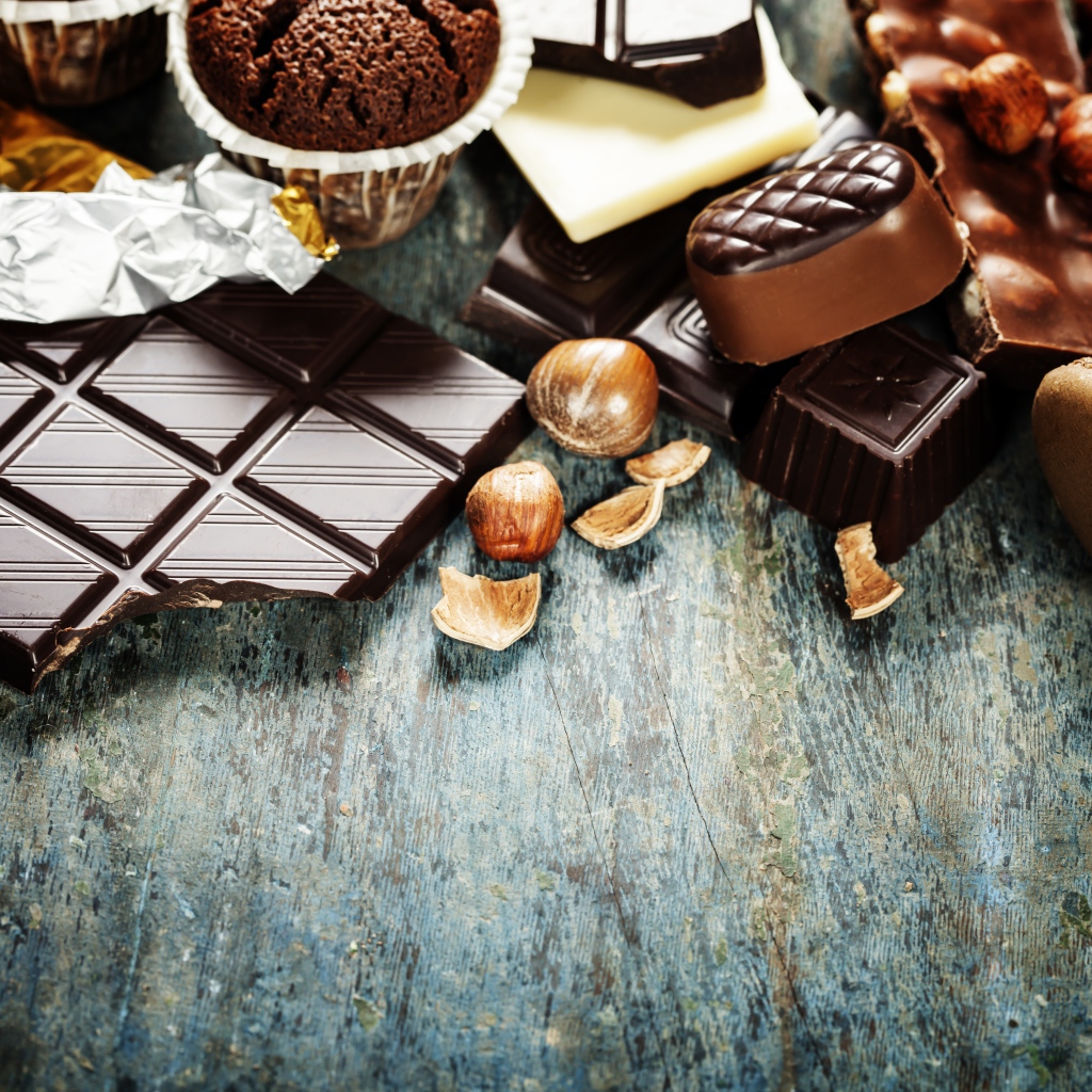 Шоколад на столе с орехами, кексами и конфетами 