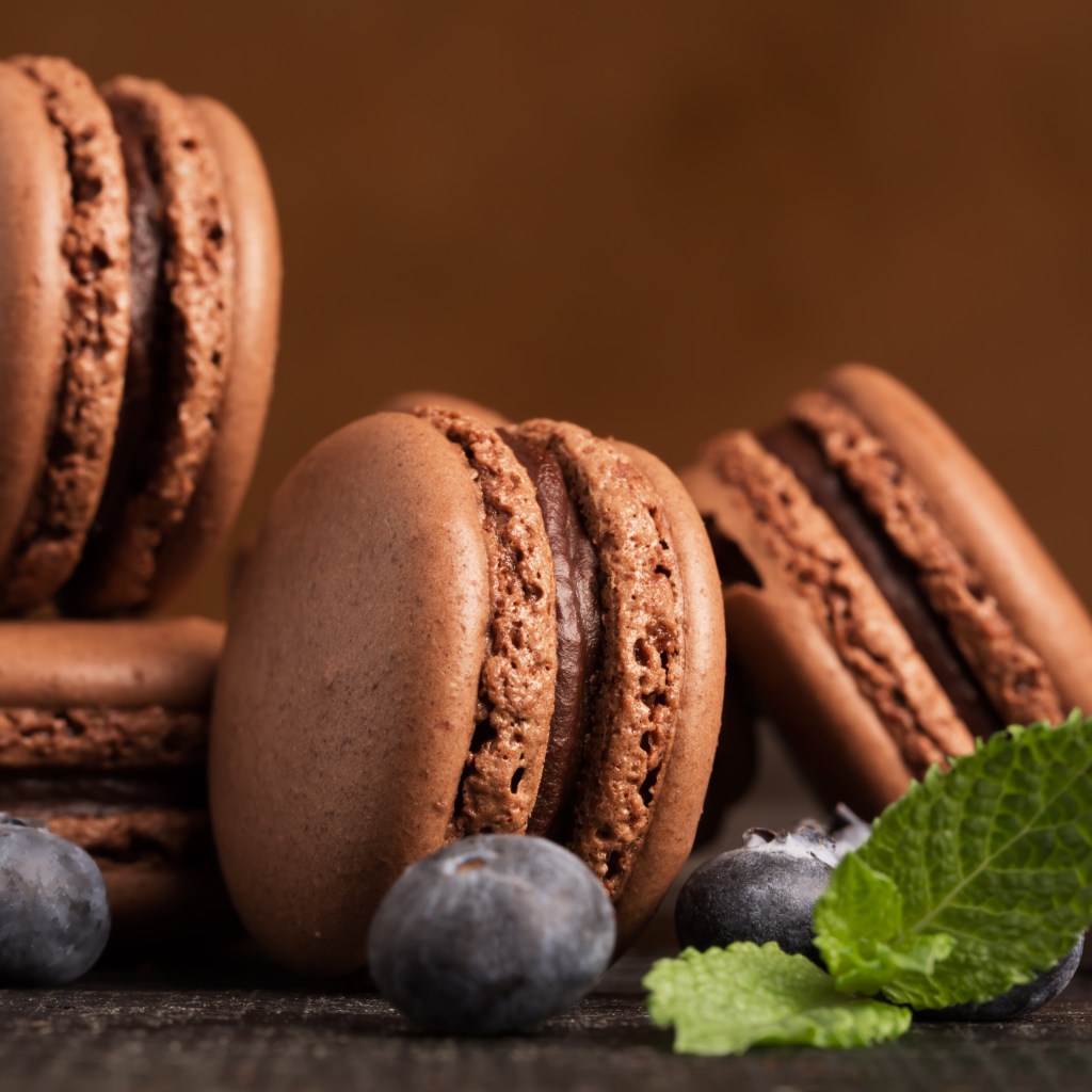 Шоколадный десерт макарон на столе с черникой 