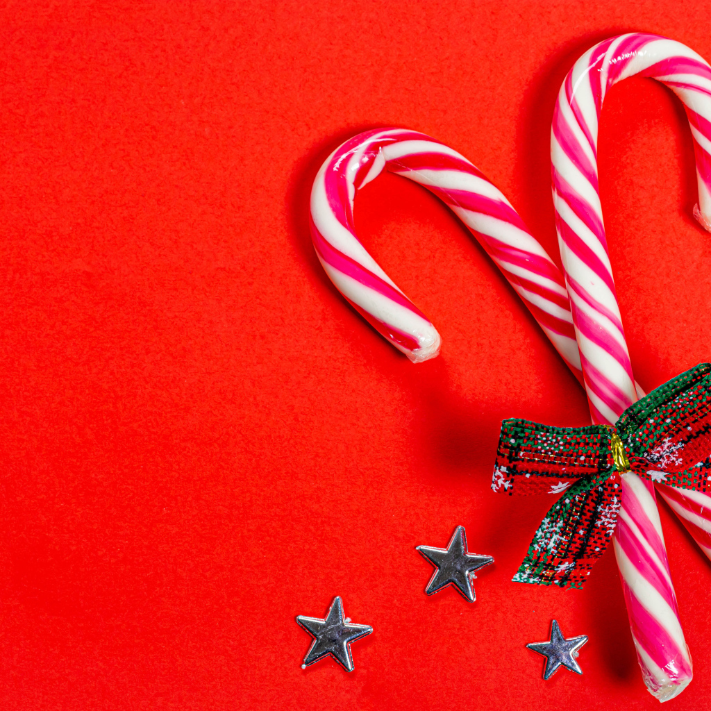 Рождественские леденцы с бантом на красном фоне