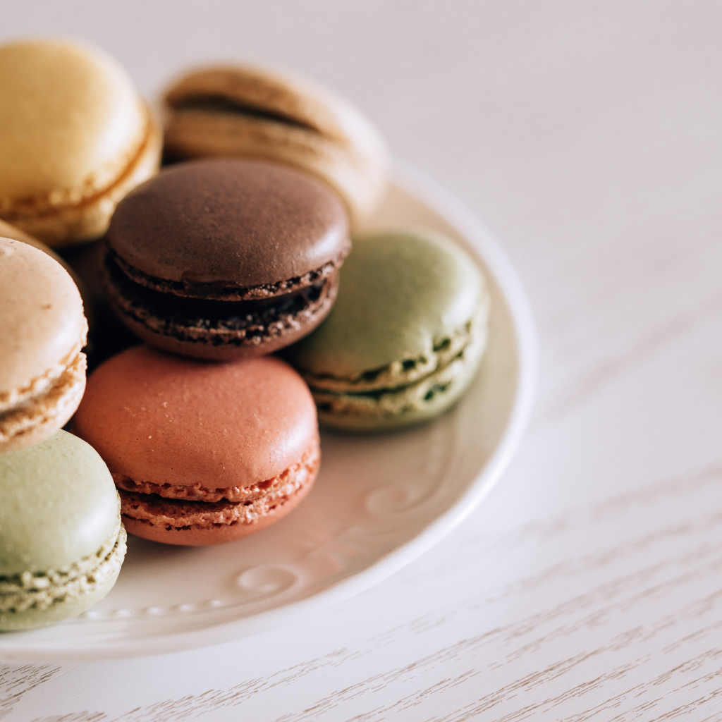 Разноцветный свежий десерт макарон на большой тарелке 