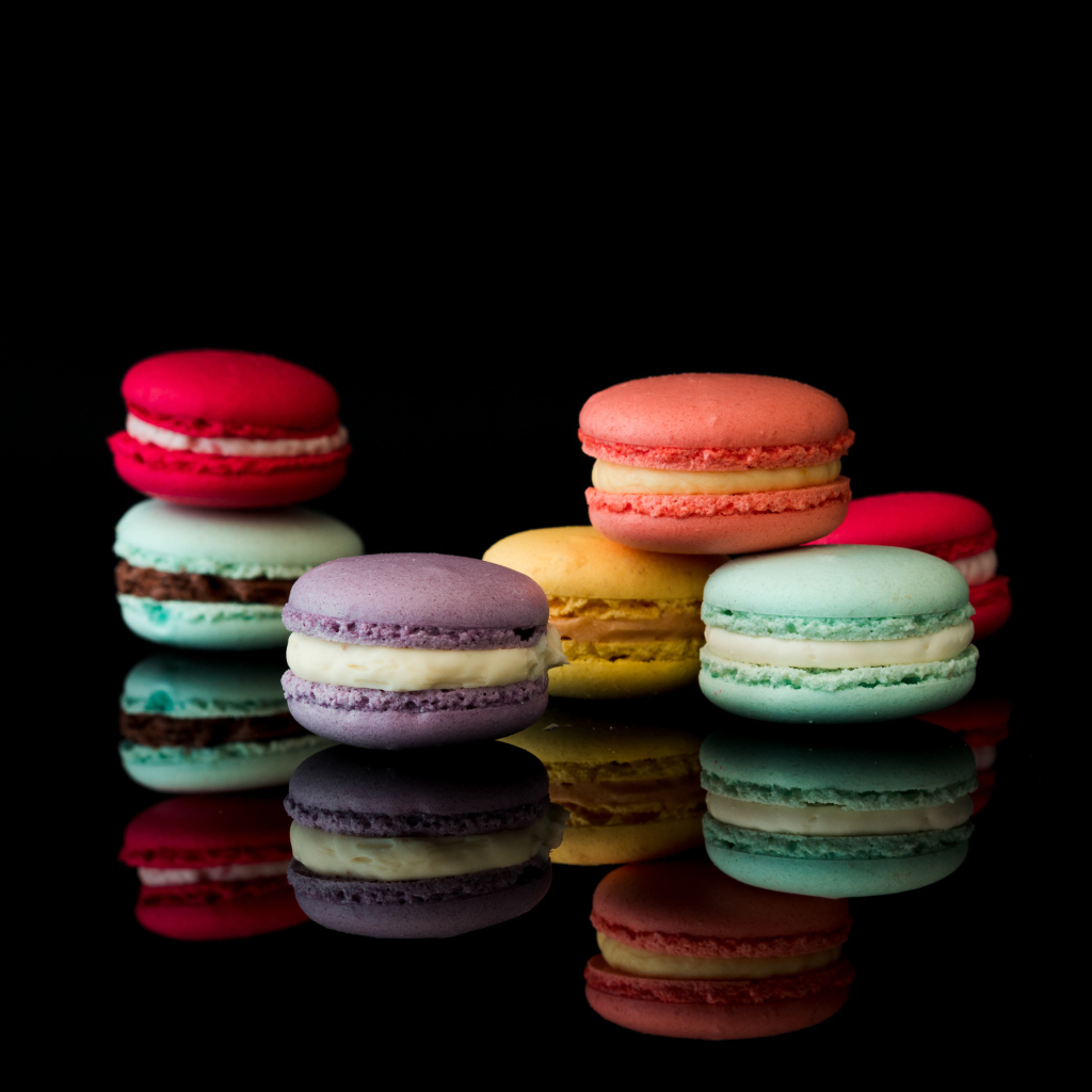 Разноцветный десерт макарун на черном фоне
