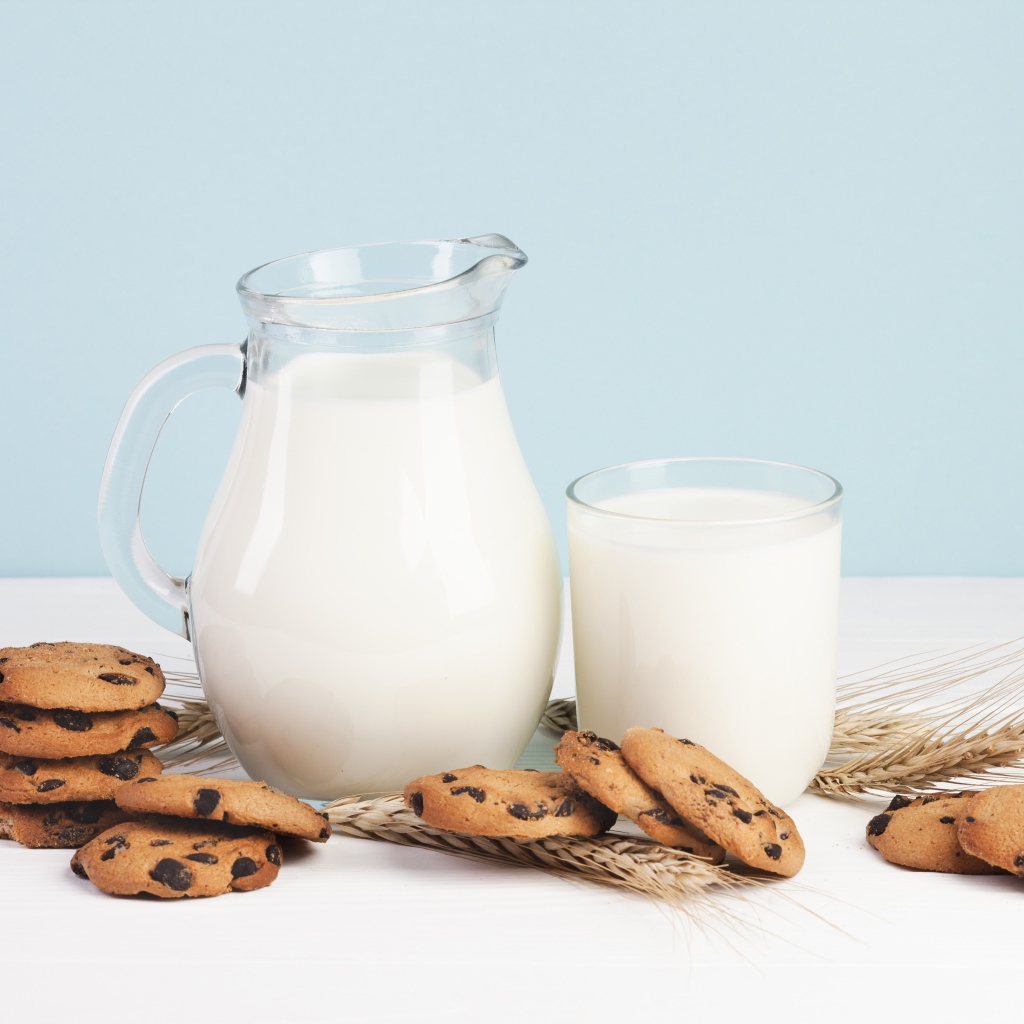 Печенье с шоколадом на столе с молоком и колосьями пшеницы