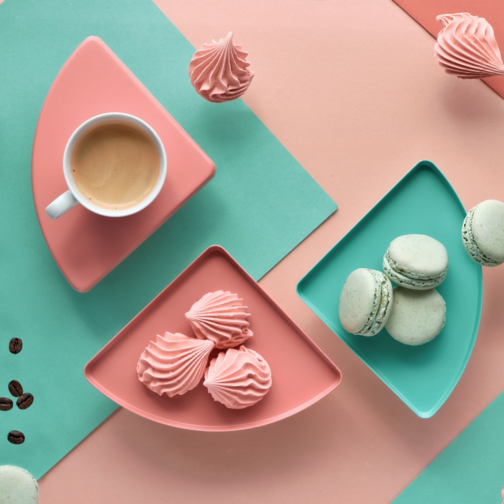 Чашка какао на столе с зефиром и десертом макарон 