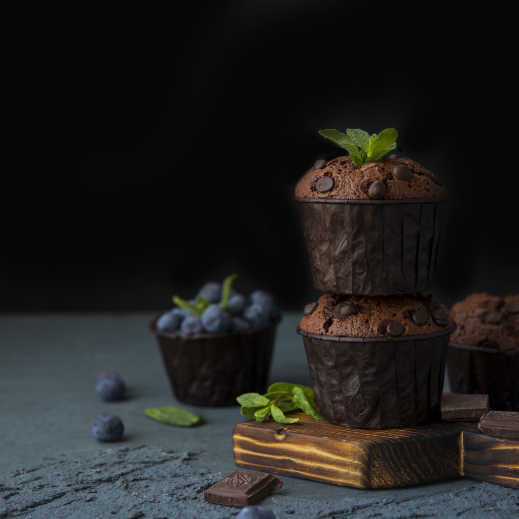 Кексы с шоколадом на столе с ягодами черники на столе 