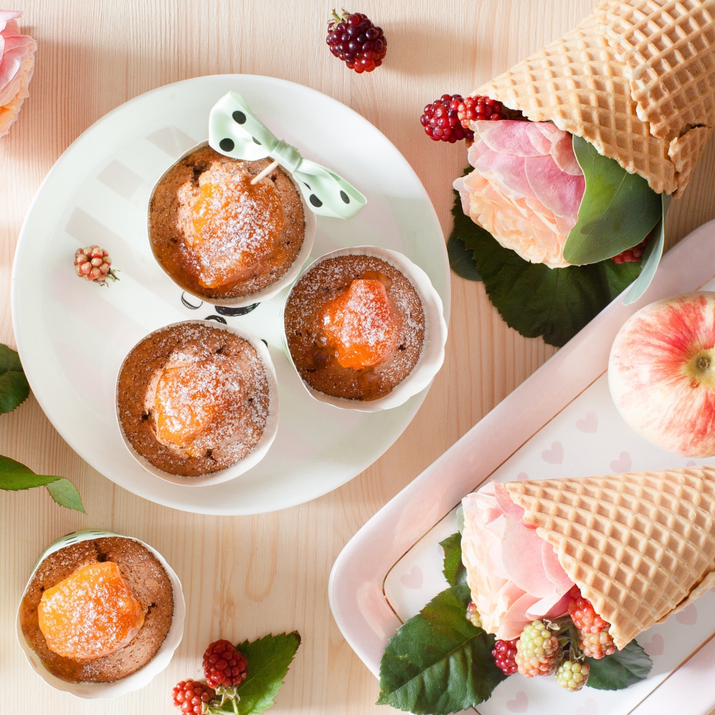 Вкусные кексы с абрикосом на столе с вафельными рожками с розой и ежевикой