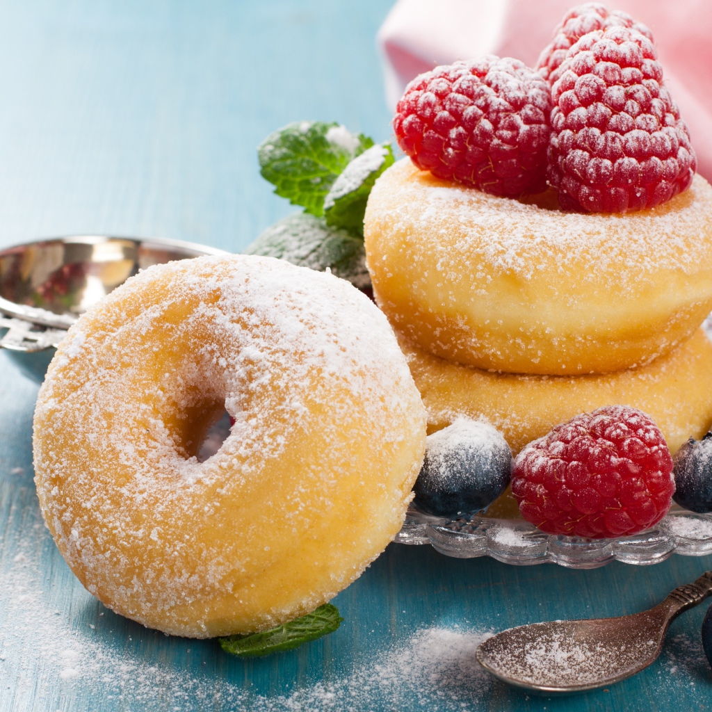 Вкусные пышные пончики с ягодами черники и малины с сахарной пудрой 
