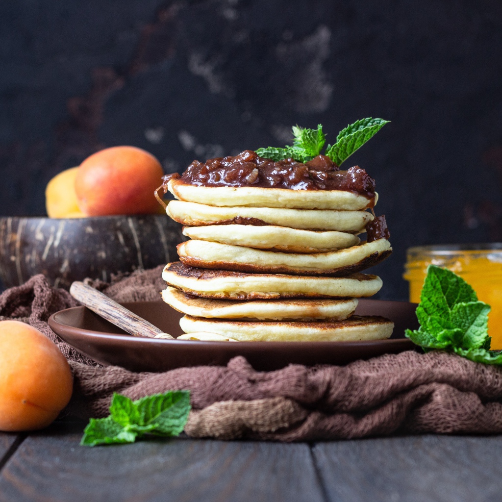 Вкусные оладьи на тарелке с джемом