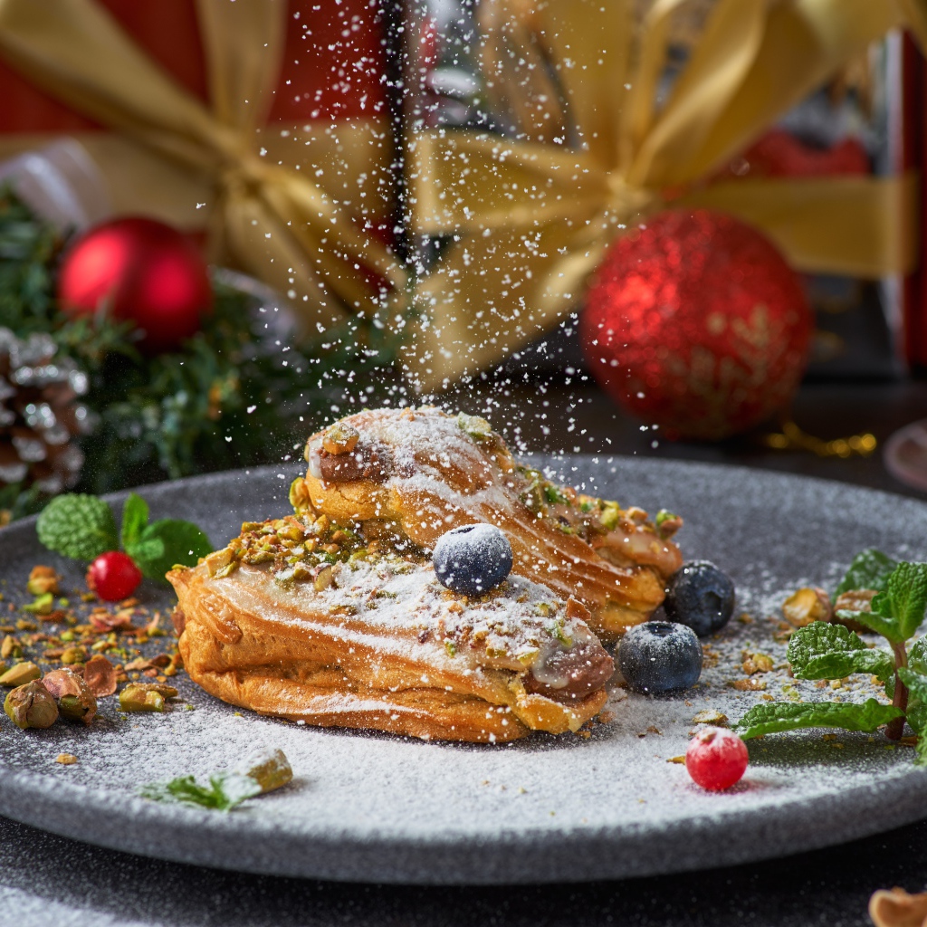 Вкусные сладкие эклеры с сахарной пудрой на блюде с ягодами 