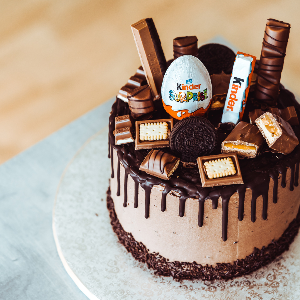 Праздничный шоколадный торт украшен сладостями