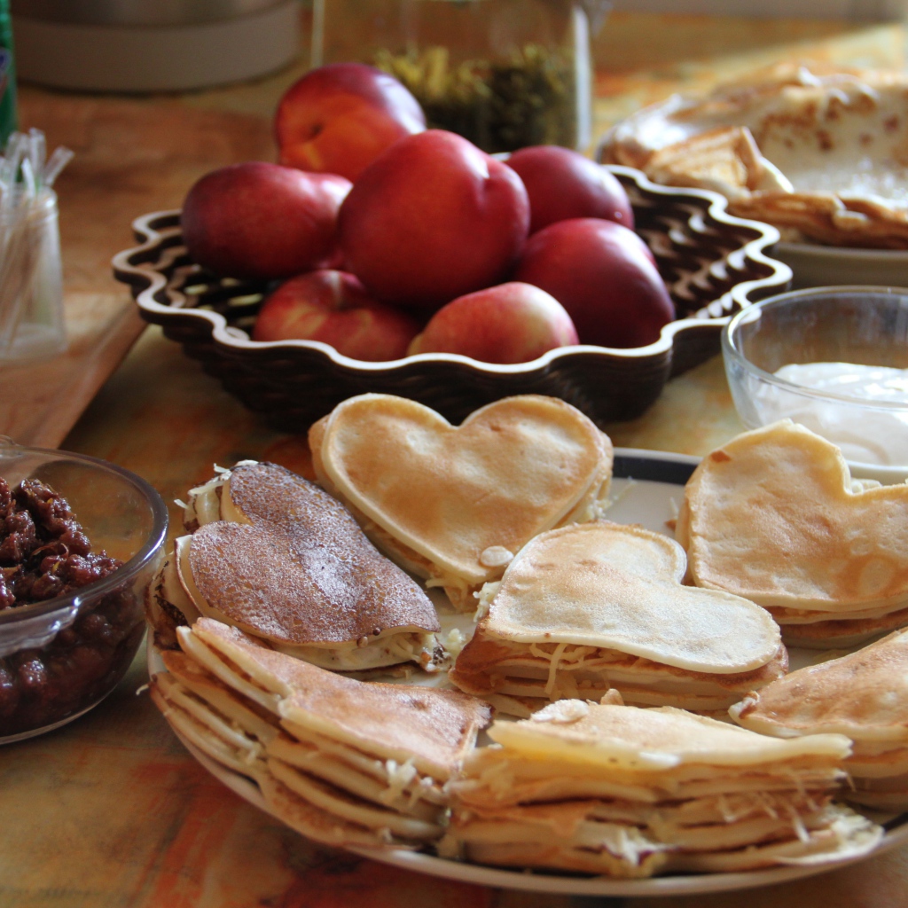 Блины с начинкой на столе с нектарином