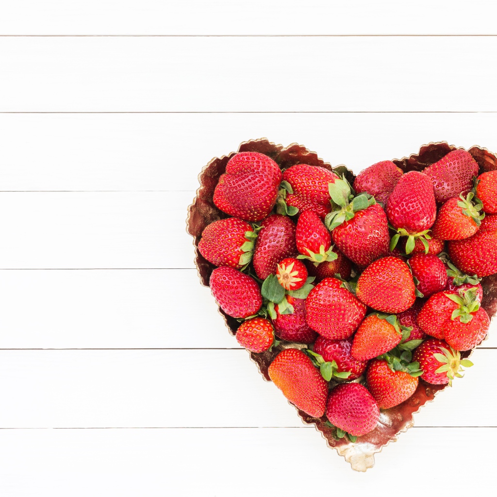 Пирожное в форме сердца с клубникой на белом фоне